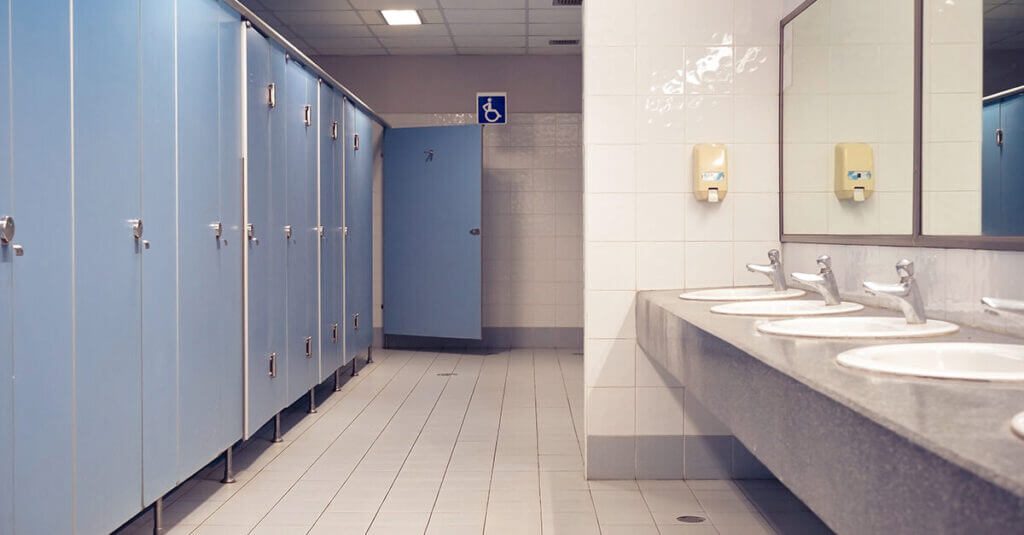 A sparkling clean restroom featuring sanitized sinks, mirrors, and floors, professionally maintained to ensure a hygienic and welcoming environment.