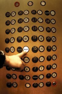 Elevator buttons being used by employee. Disinfected by Fort Worth Cleaning Professionals.