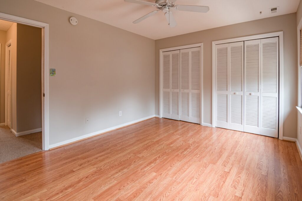Empty bedroom in Fort Worth, TX, after move-out cleanup, with spotless bare floors and clean, bright walls with no furniture present.
