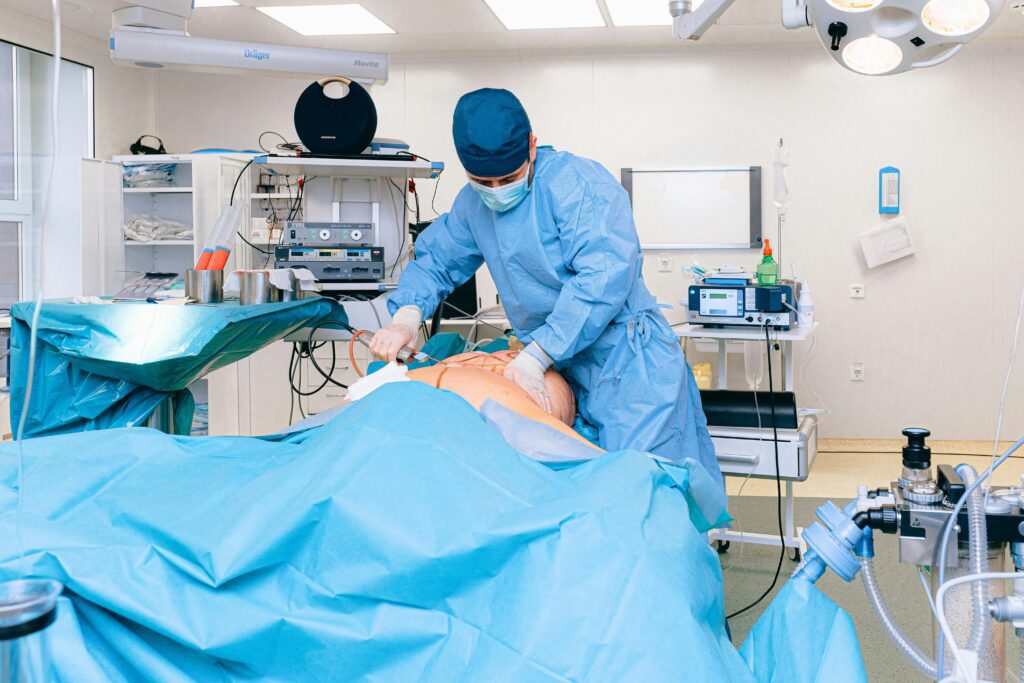 A patient lies on a surgery bed in a well-lit operating room, while a focused doctor in sterile surgical attire performs a procedure, surrounded by advanced medical equipment and monitors displaying vital signs.