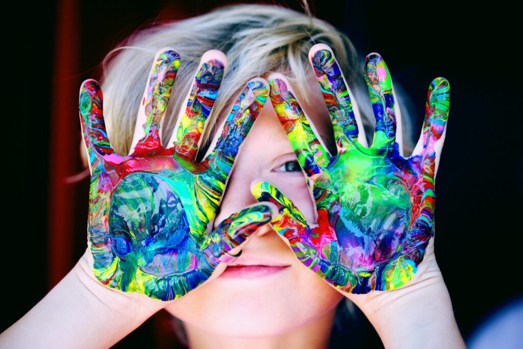 Child finger painting at a daycare in Fort Worth, Texas, in a clean and safe environment maintained by professional cleaning services.